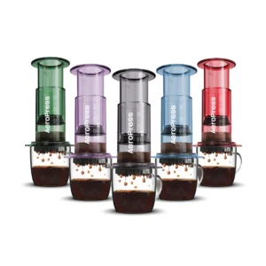 Badger and Dodo Coffee Roasters: Five vibrant Aeropress Coffee Maker-Clear Colours in shades like green, purple, gray, blue, and red stand vertically above transparent mugs filled with freshly dripping coffee.