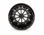 Bottom view of a black plastic coffee dripper showing a radial ribbed pattern and central drainage holes designed for even coffee extraction.