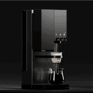A modern black coffee machine dispensing coffee into a white dripper placed above a glass carafe. The machine is shown in a dark setting with soft lighting highlighting its sleek design and control knobs.