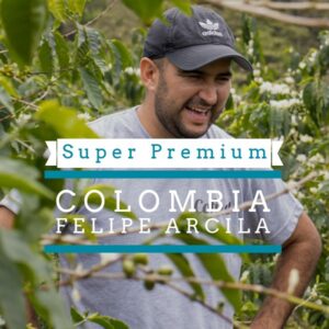 A smiling man wearing a cap and T-shirt stands among lush green coffee plants. Over the image, text reads “Super Premium” and “Colombia Felipe Arcila."