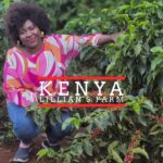 A woman kneels beside coffee plants with ripe red coffee cherries on a farm in Kenya. She is smiling and wearing a colorful pink, orange, and white patterned top and jeans. Text on the image reads “Kenya – Lillian’s Farm.”