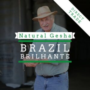Promotional coffee banner featuring an older man wearing a straw hat and striped shirt, standing outdoors and smiling. Overlaid text reads “Natural Gesha” and “Brazil Brilhante,” with a diagonal banner in the corner stating “Direct Trade.” The design uses green and white typography against a darkened background.