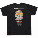 Back of a black T-shirt featuring colorful artwork of people, a church, tropical flowers, a dragon, and a coffee cup, with white text reading “Irish Aeropress Championships,” “Cork 2026,” and “Presented by Badger & Dodo Roasting Coffee.