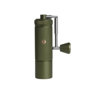 A green manual coffee grinder with a cylindrical textured body, a crank handle on the side, and a small circular logo on the front, shown against a white background.
